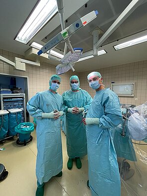 Drei Ärzte in blauer OP-Kleidung