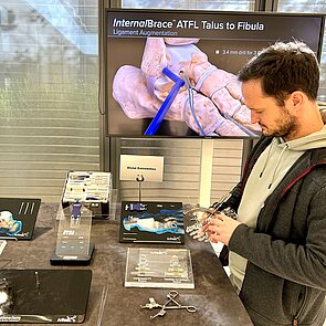 Arthrex Herr Kirsch schaut sich Prothesenmodelle an