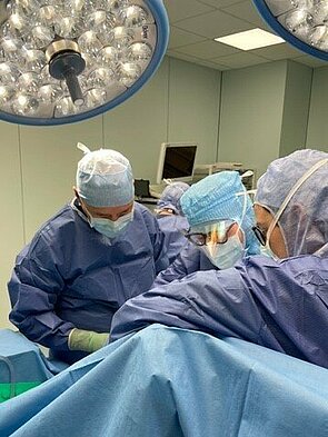 Drei Ärzte im OP-Saal bei einer Schulter-Operation